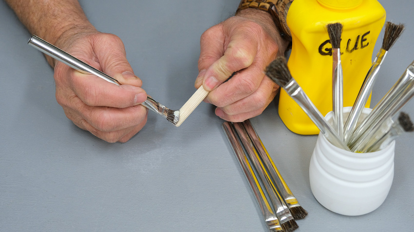  applying wood glue to dowels
